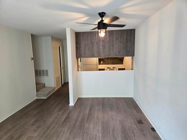 empty room with ceiling fan and dark wood-type flooring