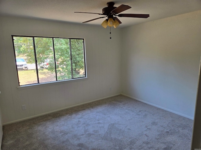 carpeted empty room featuring ceiling fan and a wealth of natural light