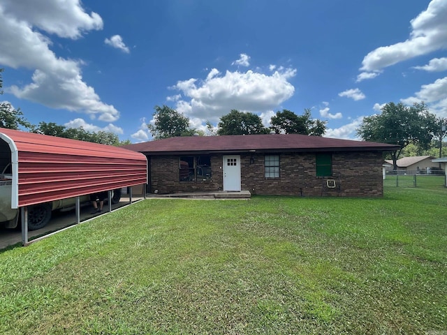 back of property featuring a carport and a yard