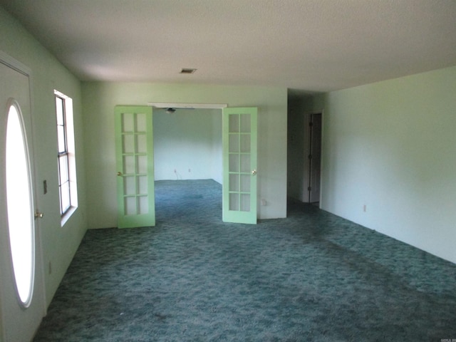 carpeted empty room featuring french doors and plenty of natural light