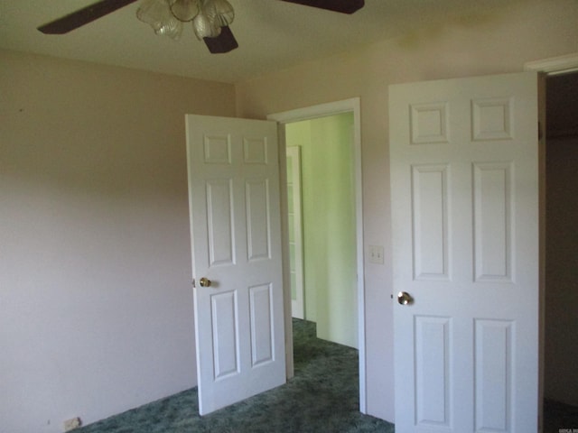 unfurnished bedroom featuring ceiling fan and dark carpet