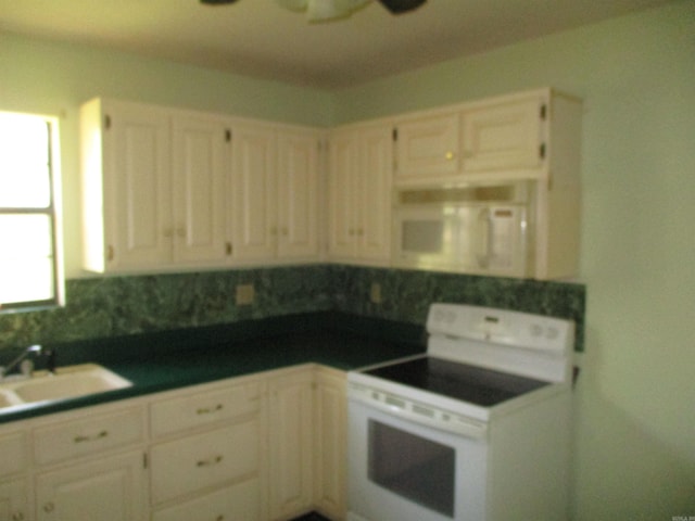 kitchen featuring white appliances, white cabinets, ceiling fan, and sink