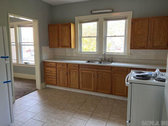 kitchen with tasteful backsplash, sink, white appliances, and plenty of natural light