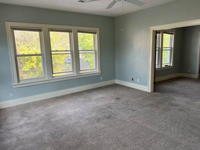 carpeted empty room featuring ceiling fan