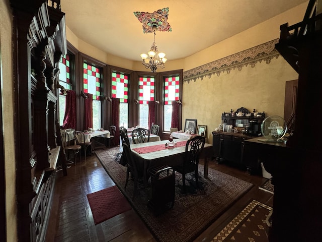 dining space with dark hardwood / wood-style flooring and a chandelier