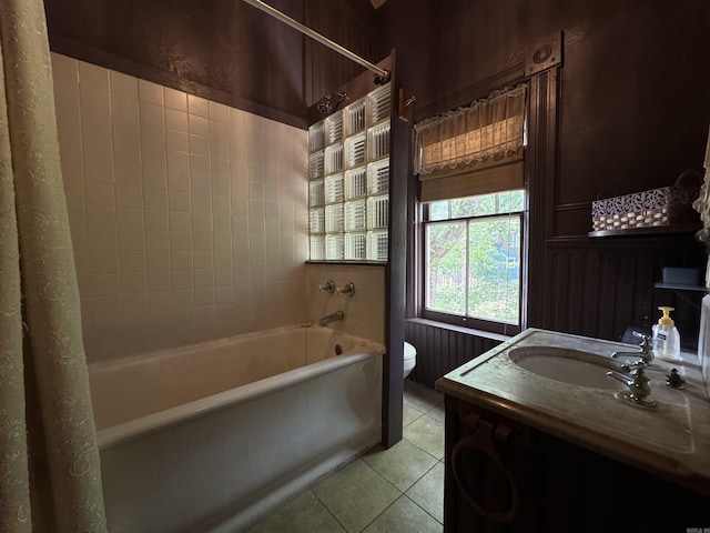 full bathroom featuring tile patterned flooring, vanity, tiled shower / bath, and toilet