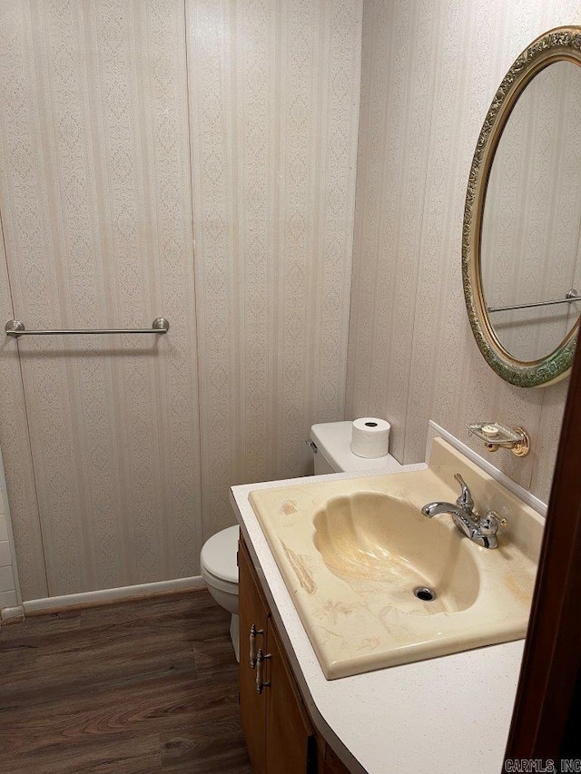 bathroom with hardwood / wood-style floors, vanity, and toilet