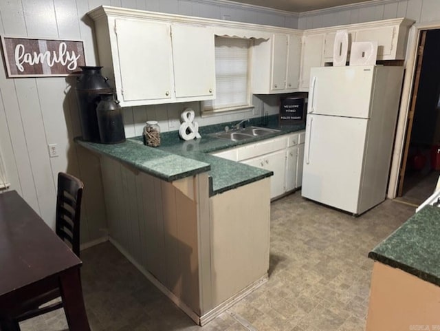 404 S Oak St, Fordyce, AR 71742 - kitchen with dark countertops, freestanding refrigerator, a peninsula, light floors, and a sink