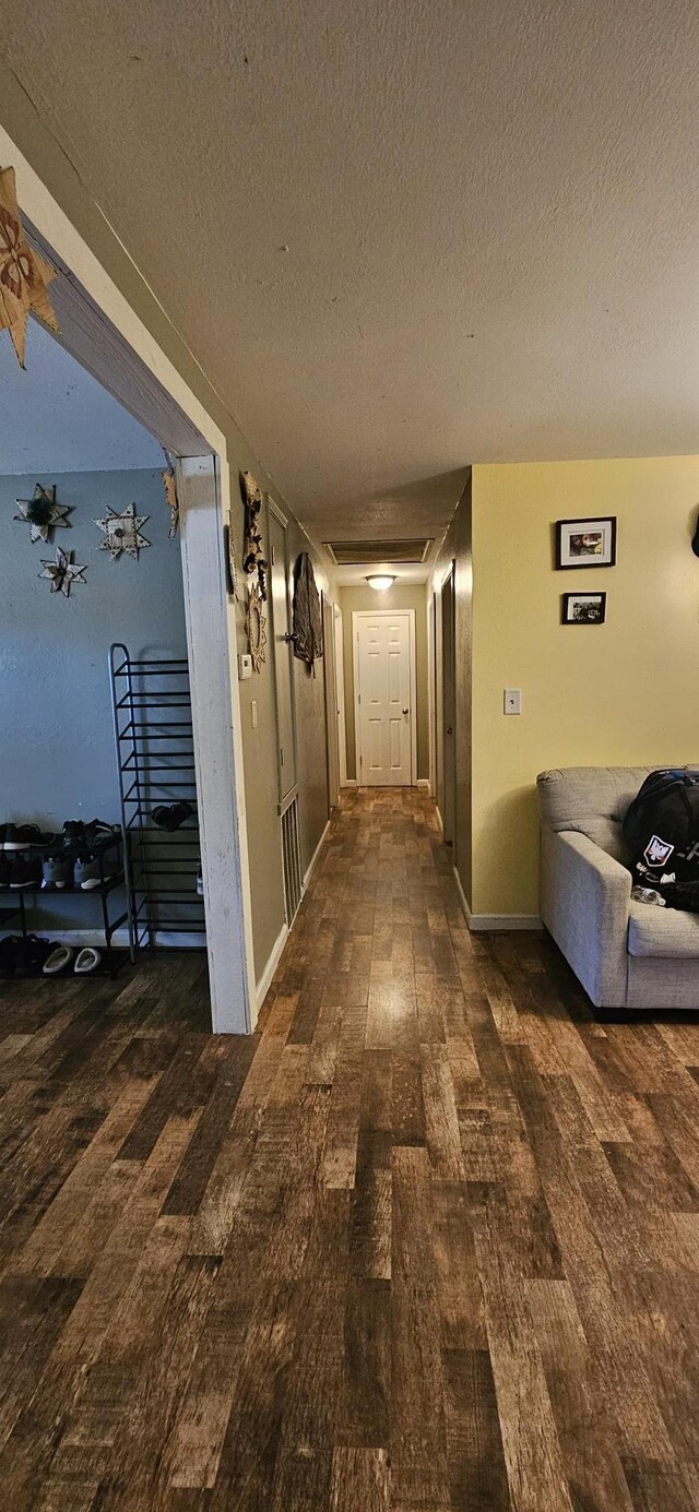 hall featuring a textured ceiling and wood-type flooring