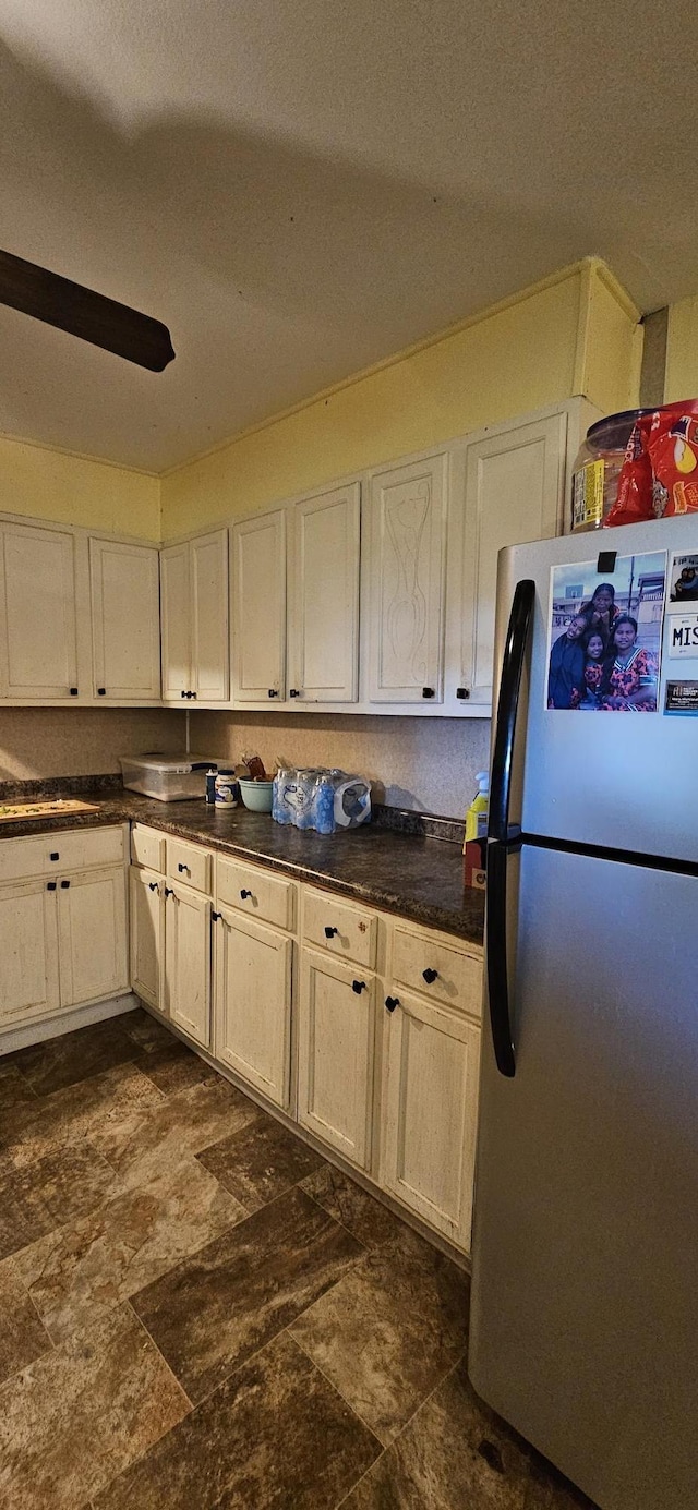 kitchen with stainless steel refrigerator and white cabinets