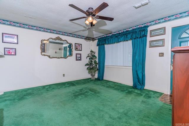 carpeted empty room with ceiling fan and a textured ceiling