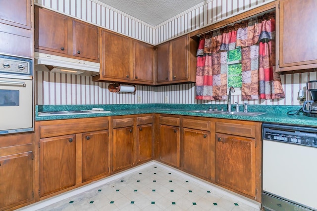 kitchen featuring a textured ceiling, sink, and white appliances