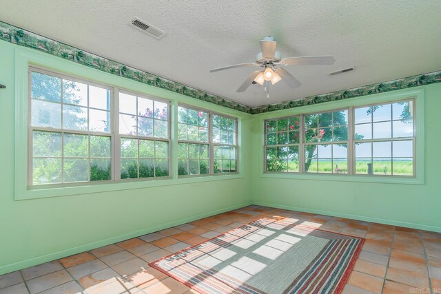 unfurnished sunroom featuring ceiling fan