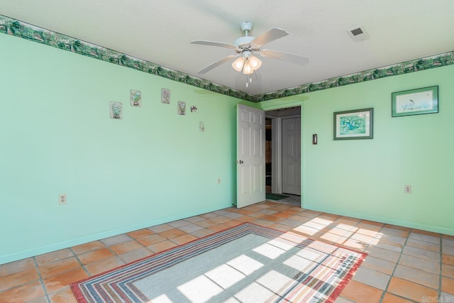 tiled spare room featuring ceiling fan and a textured ceiling