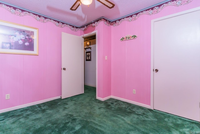 unfurnished bedroom with a textured ceiling, dark carpet, and ceiling fan