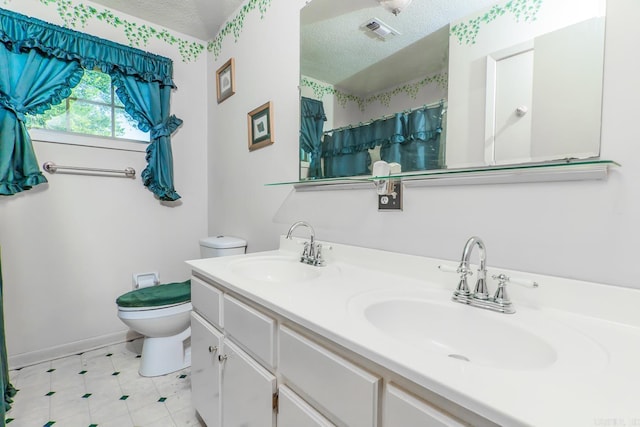 bathroom featuring vanity, a textured ceiling, and toilet