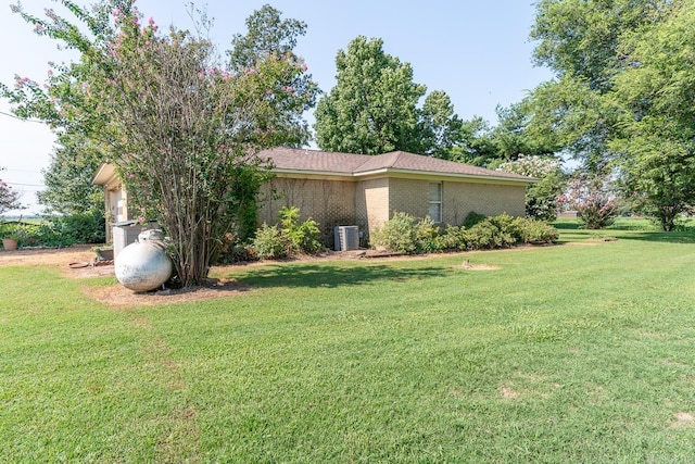 view of property exterior with a lawn and central AC unit