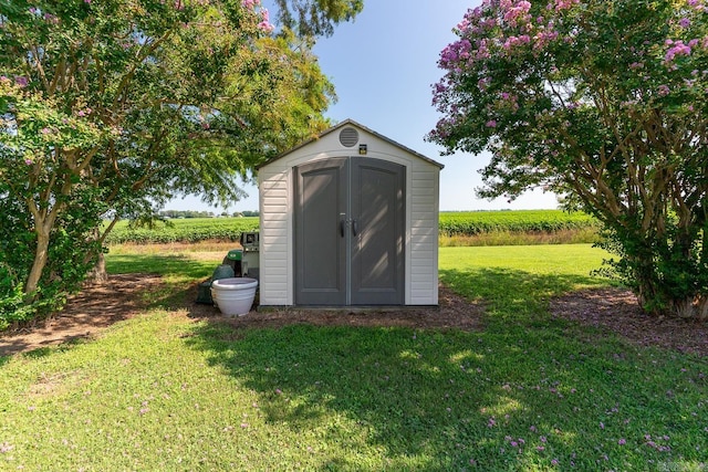 view of outbuilding with a lawn and a rural view