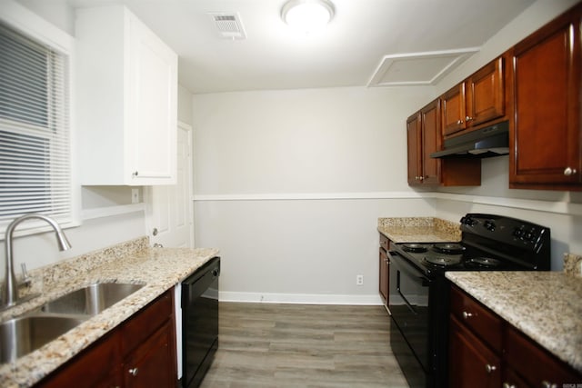 kitchen featuring sink, light stone counters, light wood-type flooring, and black appliances