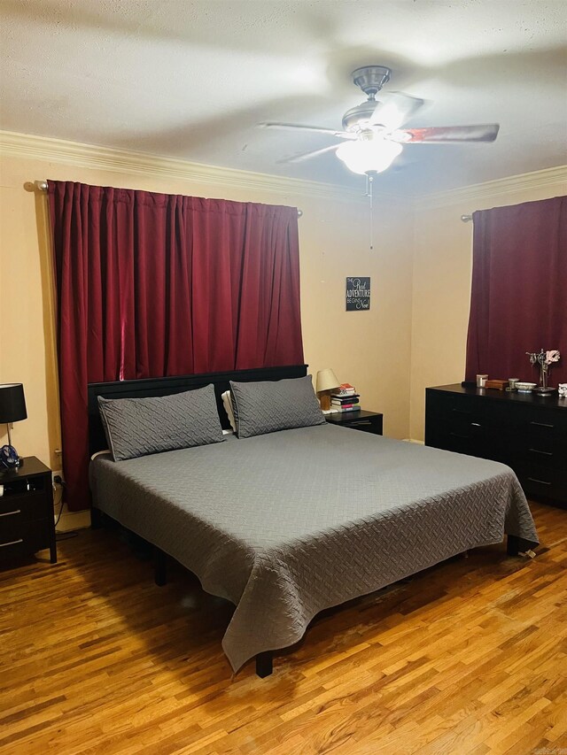 bedroom with ceiling fan, hardwood / wood-style flooring, and ornamental molding