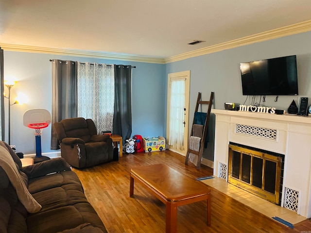 living room featuring a fireplace, crown molding, hardwood / wood-style floors, and plenty of natural light