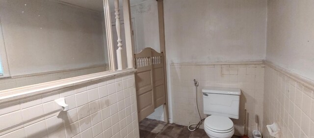 bathroom with tile walls and toilet