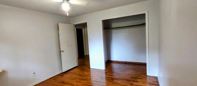 unfurnished bedroom featuring dark wood-type flooring and a closet