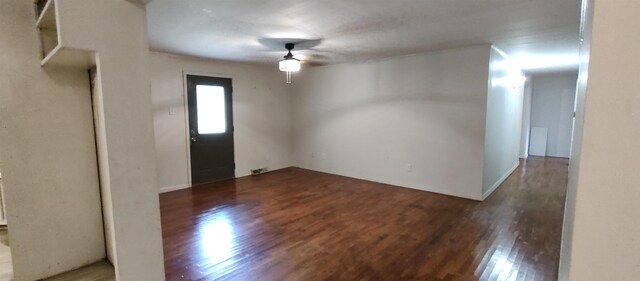 empty room featuring dark wood-type flooring and ceiling fan