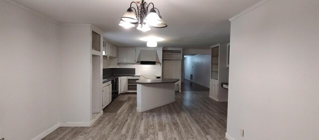 kitchen featuring wall chimney exhaust hood, white cabinetry, black dishwasher, a kitchen island, and pendant lighting