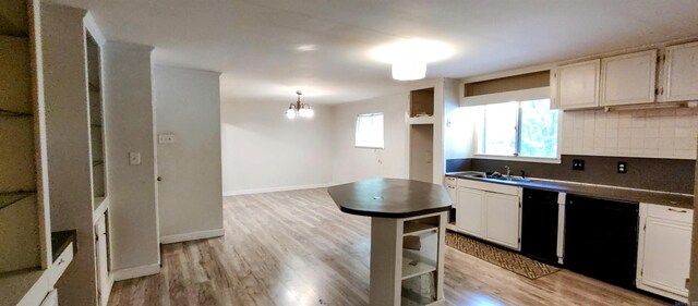 kitchen featuring a healthy amount of sunlight, sink, decorative backsplash, and white cabinets