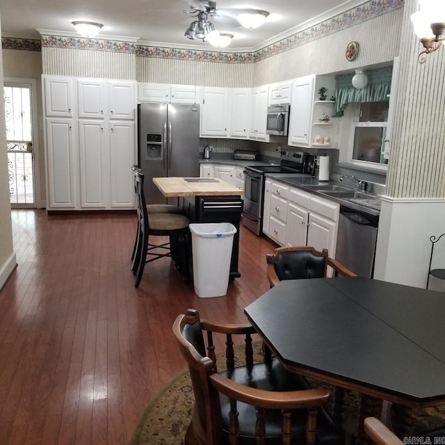 kitchen featuring sink, a kitchen island, wooden counters, white cabinets, and appliances with stainless steel finishes