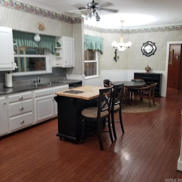 kitchen featuring white cabinets, a center island, pendant lighting, and sink