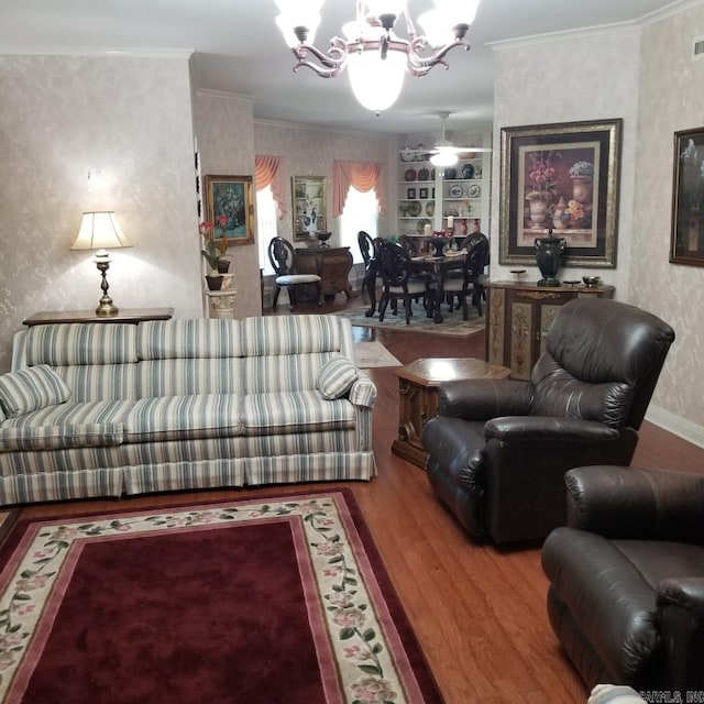 living room with hardwood / wood-style floors, an inviting chandelier, and crown molding