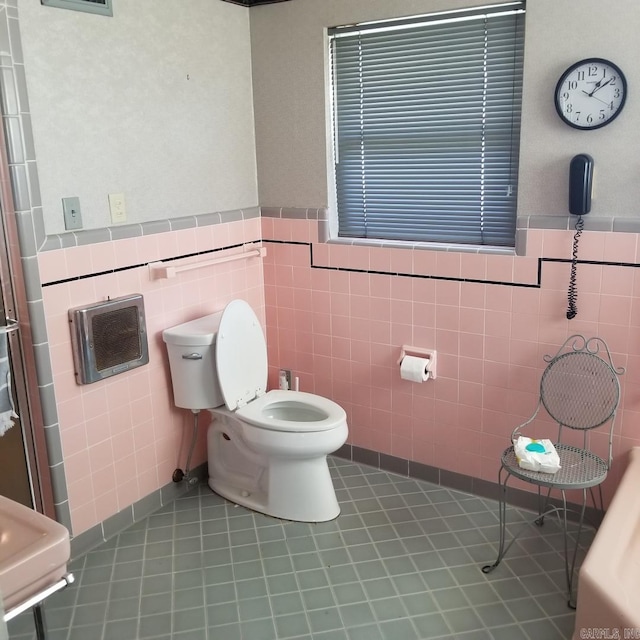 bathroom featuring tile patterned flooring, toilet, and tile walls