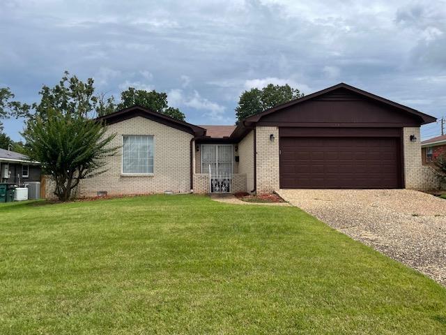 single story home featuring a garage and a front lawn