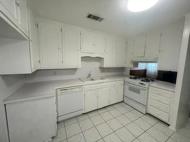 kitchen featuring sink, white appliances, light tile patterned floors, a textured ceiling, and white cabinets