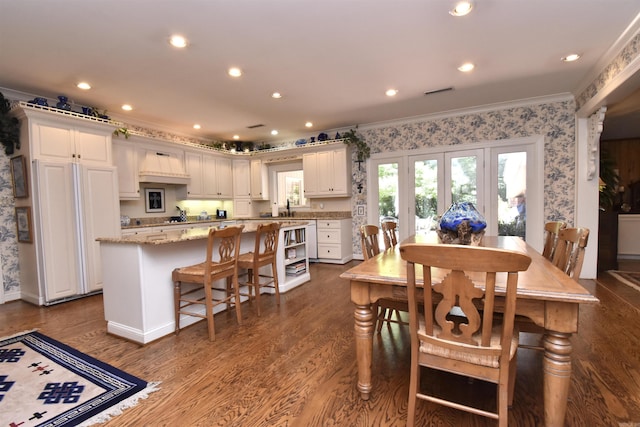 dining area with ornamental molding, sink, and hardwood / wood-style floors