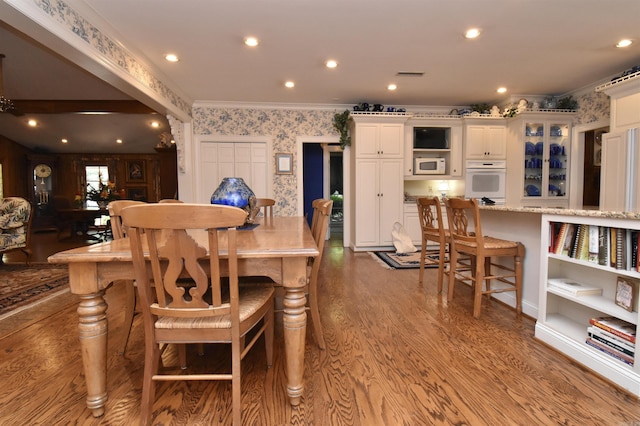 dining space with hardwood / wood-style flooring and ornamental molding