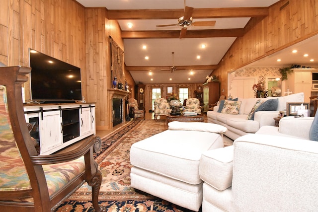 living room with ceiling fan, lofted ceiling with beams, and wood walls