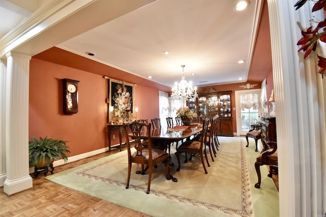 dining room with a chandelier, light parquet floors, and ornate columns