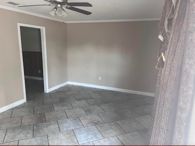 empty room with dark tile patterned floors, ornamental molding, and ceiling fan