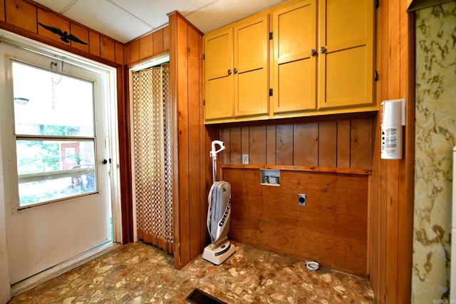 laundry area with wood walls, cabinets, hookup for a washing machine, and electric dryer hookup