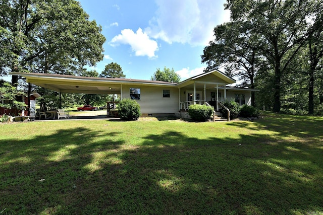 rear view of property featuring a carport, covered porch, and a lawn