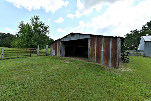 view of outbuilding featuring a rural view and a yard