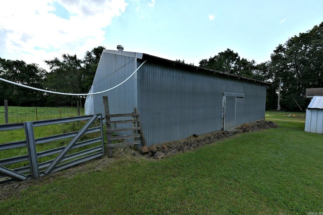 view of side of property with an outdoor structure and a yard