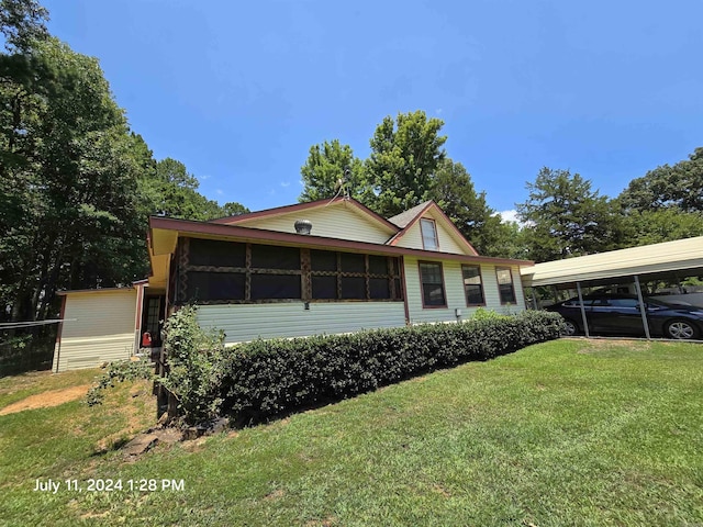 view of front facade featuring a carport, a sunroom, and a front yard