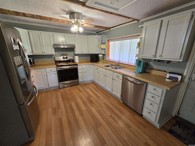 kitchen with sink, white cabinetry, crown molding, light wood-type flooring, and appliances with stainless steel finishes