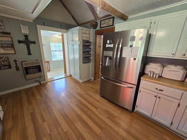 kitchen featuring heating unit, light wood-type flooring, stainless steel fridge, beam ceiling, and white cabinets