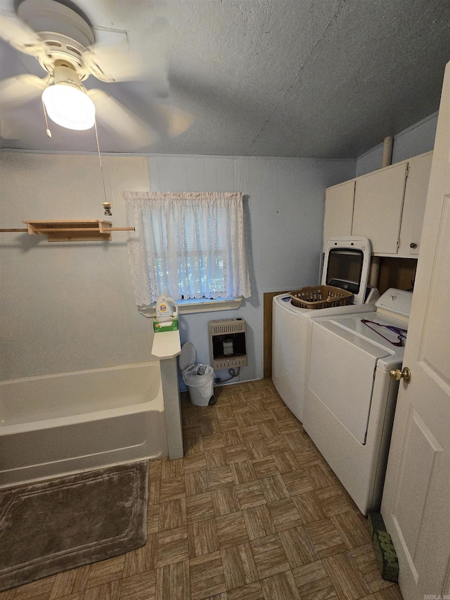 laundry room featuring heating unit, cabinets, dark parquet floors, ceiling fan, and washer and clothes dryer