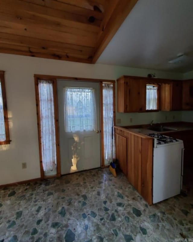 kitchen with sink, wood ceiling, and white gas range oven